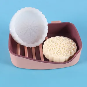 Detailed view of translucent silicone mold and finished mooncake-patterned soap in a pink tray