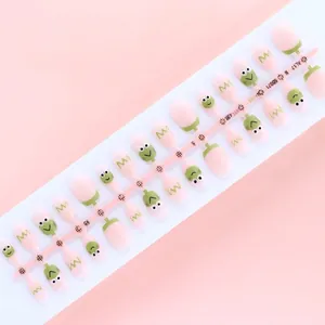 Detail view of 30pcs frog prince themed press-on nails on a soft pink background