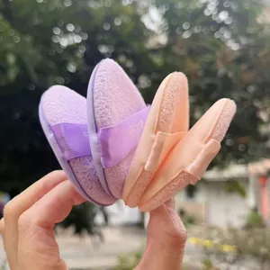Detailed macro shot of dual-sided makeup sponges in purple and peach for smooth skin.