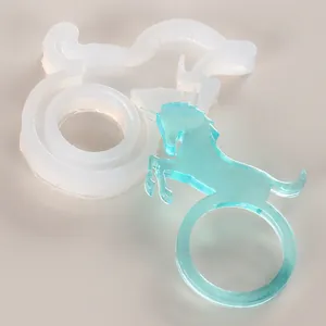 Close-up detail of a unicorn ring silicone mold and a translucent blue resin finished piece