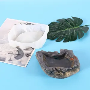 Detail view showing a white silicone leaf mold and finished resin ashtray on blue surface