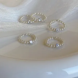 Verfijnd detail van parelringen met een sprankelende vierkante zirkonia in het middenstuk