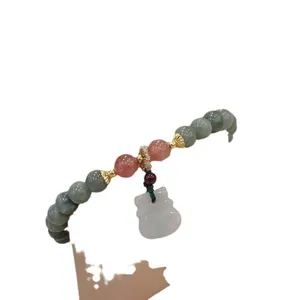 Bracciale artigianale in giada e cristallo fragola con un raffinato ciondolo in giada bianca.