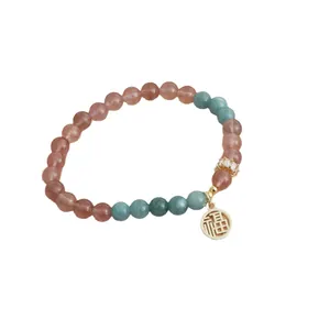 Elegant natural strawberry quartz bead bracelet featuring a golden lucky Fu charm