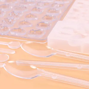 Detail view of transparent stirring spoons and silicone molds for DIY resin jewelry making