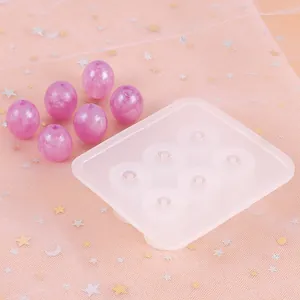 Detail van een siliconen mal met 6 holtes en paarse harskralen voor DIY-sieraden maken