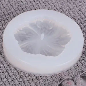 Detailansicht einer Sonnenblumen-Silikonform für DIY-Harzschmuck auf grauem Stoffhintergrund.