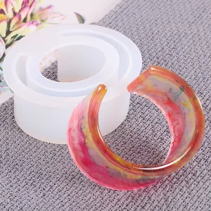 Detail view of DIY C-shaped bracelet silicone mold and finished colorful resin cuff
