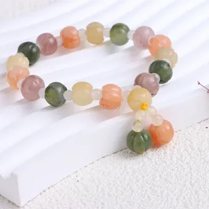 Nahaufnahme eines natürlichen Xinjiang Goldseide Jade Armbands mit bunten Kürbisperlen