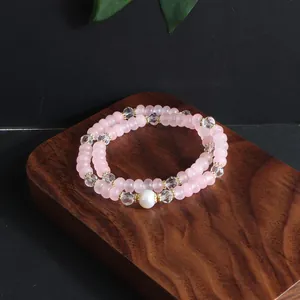 Detailed view of pink opal and crystal beaded double-layer bracelet with pearl