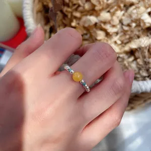 Close-up shot of a natural stone crystal beaded ring worn on a hand with silver beads
