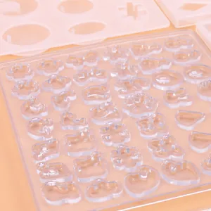 Close-up detail of a clear silicone resin mold tray with various small jewelry shapes