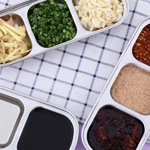 Close-up of stainless steel divided trays filled with fresh spices and sauces