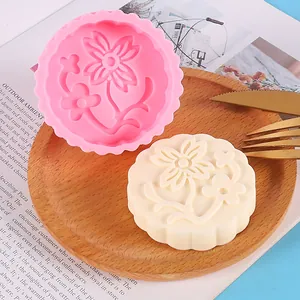 Detailed view of pink silicone flower mold and its white wax melt cast on a wooden tray