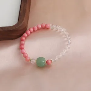 Detailansicht eines rosa Rhodochrosit-Armbands mit Bergkristall und grüner Kürbisperle