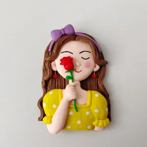 Detailed close-up of a cute clay girl figurine holding a red rose for cake decoration