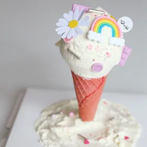 Detailed view of colorful ice cream cone cake toppers with rainbow and daisy decorations