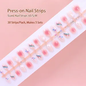 Detailed view of pink and white press-on nails with rainbow and flower patterns