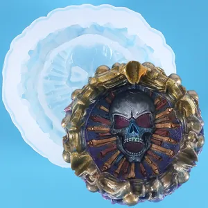 Macro detail of gothic skull ashtray resin mold alongside a finished metallic piece
