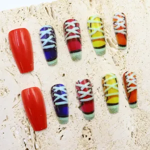 Detail view of long coffin press-on nails with retro colorful shoelace patterns.