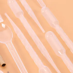Close-up detail of transparent plastic pipettes and spoon for DIY resin jewelry making kit