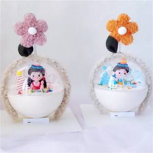 Detail view of cute cartoon boy and girl figurine cake toppers with plush flowers