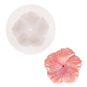 Detaillierte Ansicht einer Blumensilikonform neben einem rosa schillernden Harzguss.