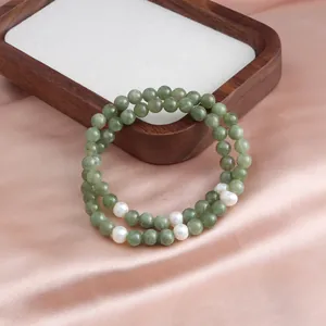 Close-up of a New Chinese style double-strand green jade and white pearl beaded bracelet.