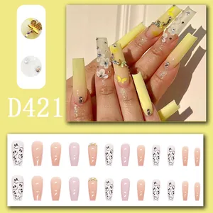 Detailed view of long coffin press-on nails with 3D floral and butterfly charms