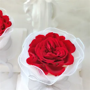Elegante decoración de pastel rosa roja con cinta de encaje de malla blanca rizada.