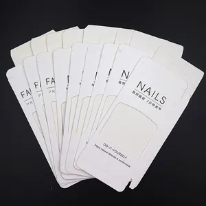 Detail of white paper packaging cards for press-on nails with hanging hole and window
