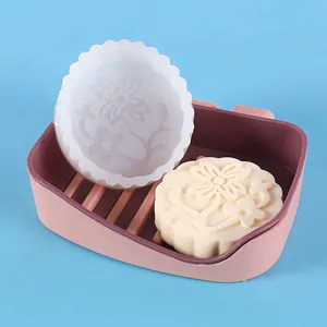 Detail showing a mooncake silicone mold and a finished flower-patterned candle or soap.