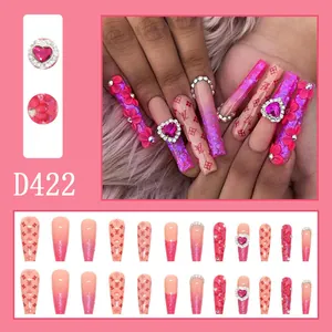 Close-up of pink gradient press-on nails with 3D flowers and heart diamond details
