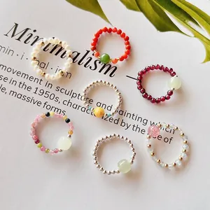 Detailed close-up of handmade elastic beaded rings with natural gemstones and pearls
