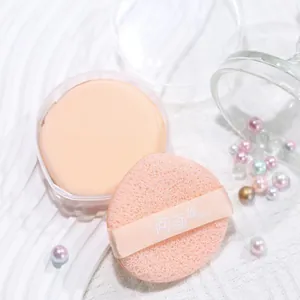 Close-up of pink dual-sided makeup puff with ribbon strap and clear storage case