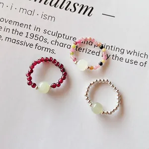 Macro view of three beaded crystal rings with moonstone centers on a minimalist background