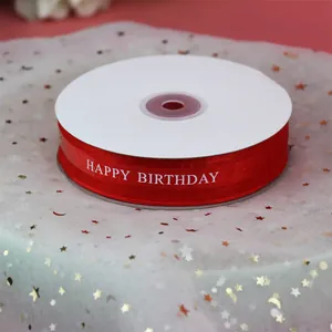 Gros plan sur un ruban en organza rouge avec texte imprimé Happy Birthday blanc