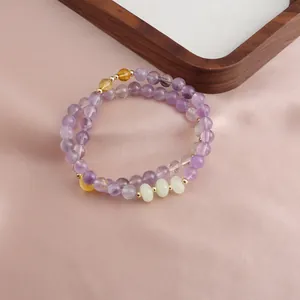 Double-strand amethyst bracelet with sunstone and agate beads on pink silk background