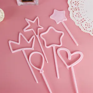 Detailed view of pink plastic cake toppers in heart, crown, and star shapes for baking.
