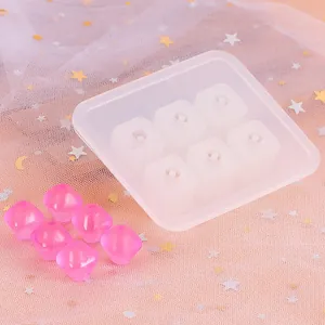 Detail van een siliconen mal met 6 holtes en roze gefacetteerde harskralen voor DIY