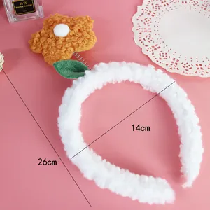 Detalle con las medidas de la diadema de flores de peluche blanca sobre fondo rosa