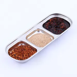Detail showing a 3-compartment stainless steel dipping sauce dish filled with various spices