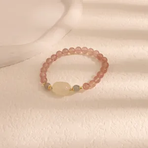 Primo piano di un braccialetto in quarzo rosa fragola con perla centrale intagliata