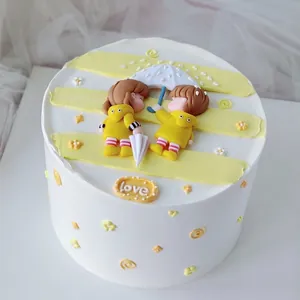 Dettaglio di cake topper con coppia carina in impermeabili per decorazione di torte romantiche