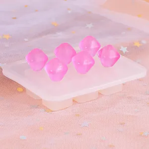 Detailopname van gefacetteerde roze harskralen op een siliconen mal voor DIY-sieraden