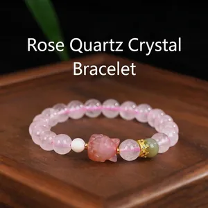 Close-up of a natural Madagascar rose quartz bracelet with a detailed pink fox charm