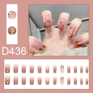 Detail view of gentle pink gradient press-on nails with 3D heart and pearl design