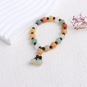 Nahaufnahme von natürlichen bunten Jade-Kürbisperlen auf einem ethnischen Armband