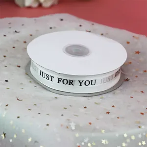 Gros plan sur un ruban de gaze de neige blanc avec imprimé 'JUST FOR YOU' pour cadeaux