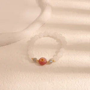 Vista macro di bracciale di perle bianche con perla rosa e ciondolo a fiore giallo